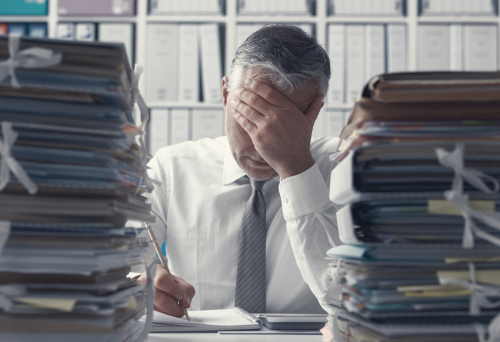 stressed businessman by Stokkete shutterstock_1051270844
