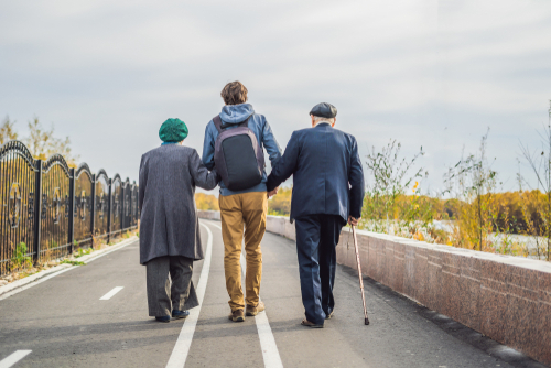 Young man walking with older couple shutterstock_1233617758